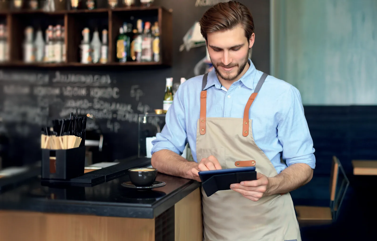 Barman al bancone del locale mentre lavora con Passepartout Menu su tablet